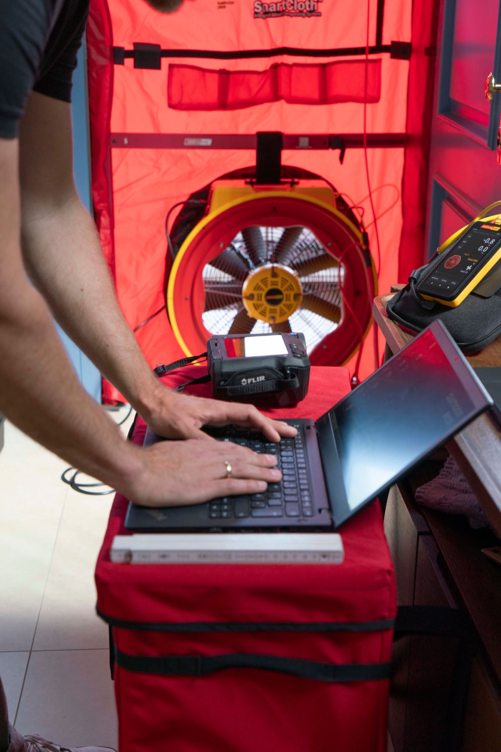 Blower-Door-Test: roter Messrahmen mit Gebläse zur Luftdichtheitsmessung